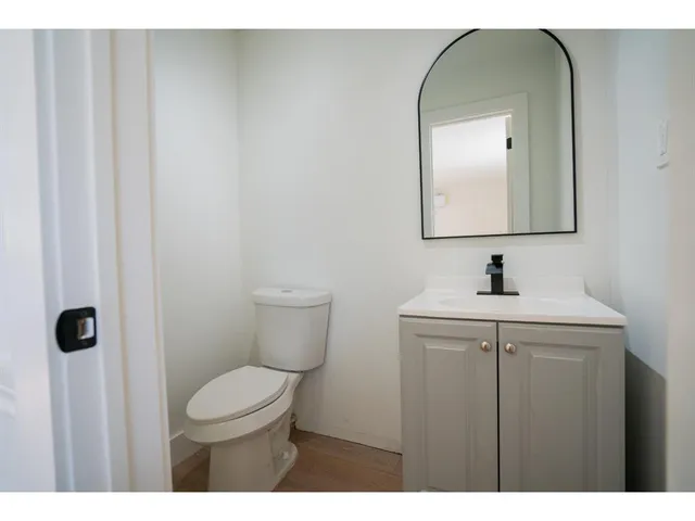 a bathroom with a toilet a sink and mirror