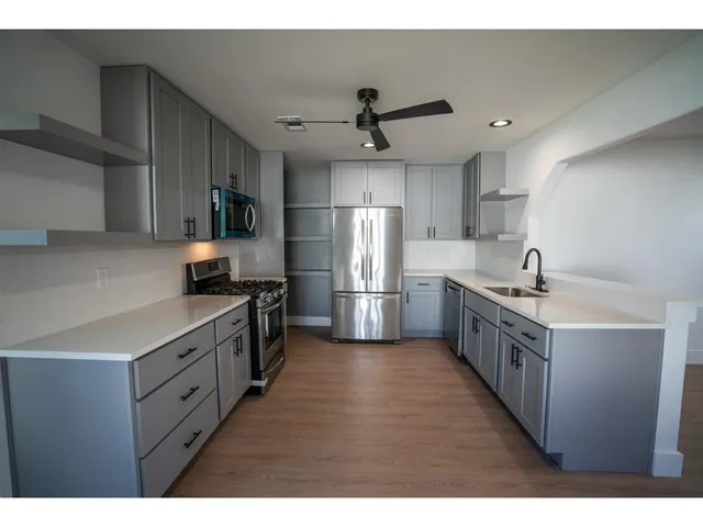 a kitchen with stainless steel appliances a sink and a refrigerator