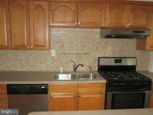 5430 Channing Road Baltimore, MD 21229 - Photo 6 of 13 a kitchen with granite countertop stainless steel appliances a stove a refrigerator a sink and cabinets