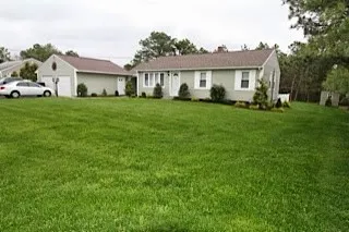 a front view of a house with a yard and trees