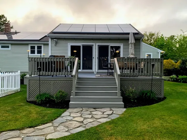 a view of a house with a small yard and a large tree front of a house