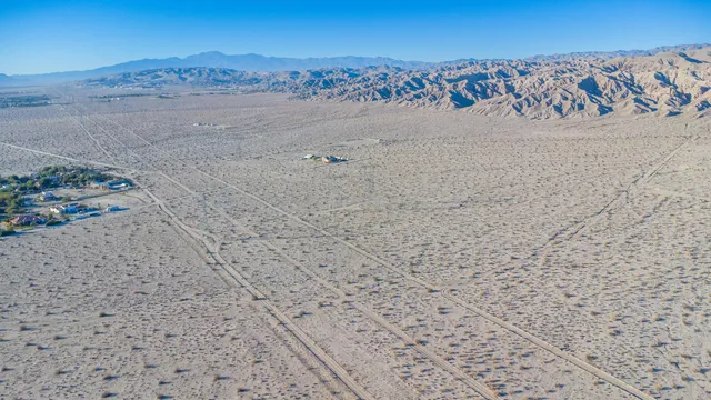 a view of a large mountain with sunset in background