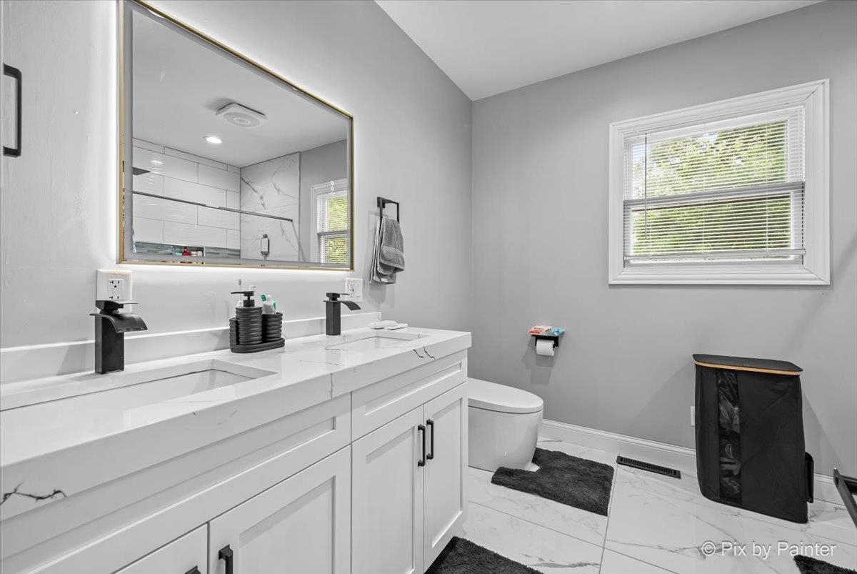 10053 Spring Road Garden Prairie, IL 61038 - Photo 7 of 17 a bathroom with a sink a toilet and mirror