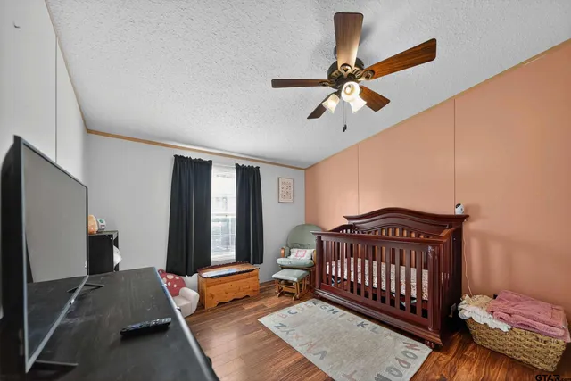 a bedroom with bed and wooden floor