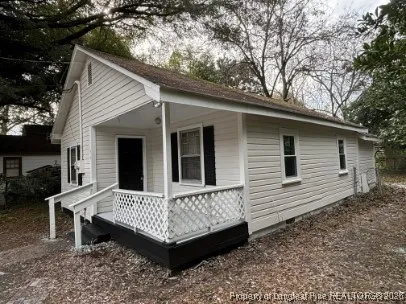 a view of a house with a yard and wooden fence
