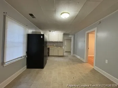 a view of a refrigerator in kitchen and a window