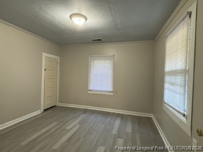1614 Reeves Street Fayetteville, NC 28306 - Photo 8 of 14 an empty room with wooden floor and windows