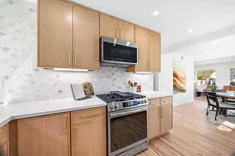 a kitchen with stainless steel appliances a stove a sink a microwave and cabinets