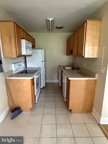 a kitchen with a sink a stove top oven and cabinets