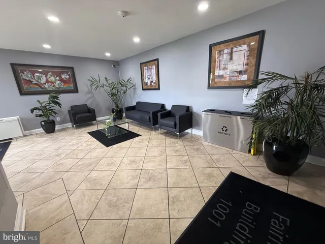 a bedroom with a bed a couch and potted plant