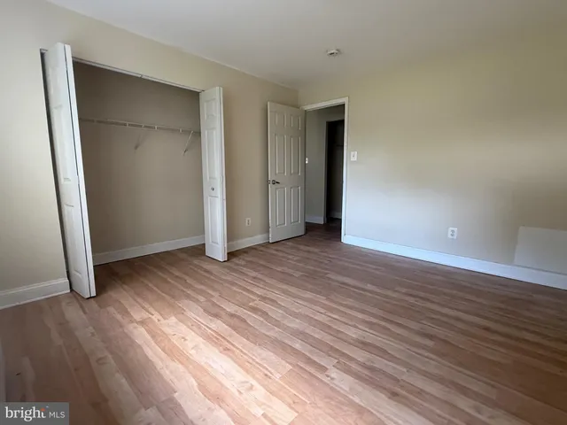 an empty room with wooden floor and closet