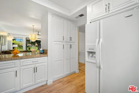 a kitchen with white cabinets and sink