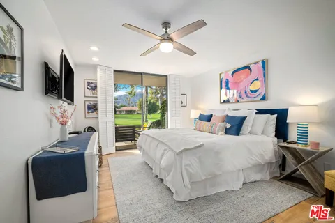 a bedroom with a large bed and a flat screen tv