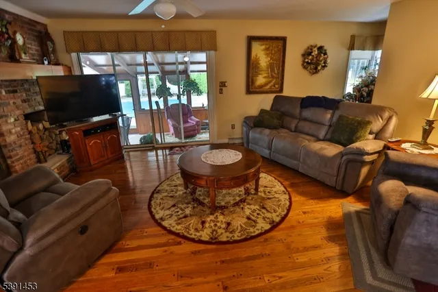 a living room with furniture a flat screen tv and a floor to ceiling window