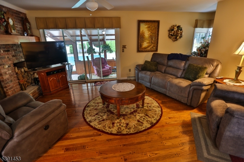 47 New Mashipacong Road Montague, NJ 07827 - Photo 12 of 42 a living room with furniture a flat screen tv and a floor to ceiling window