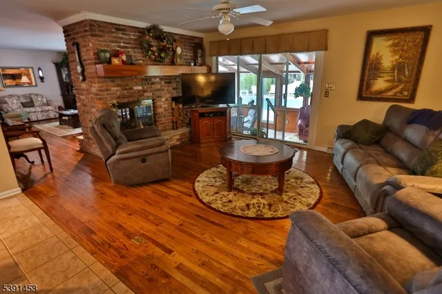 a living room with furniture a flat screen tv and a floor to ceiling window