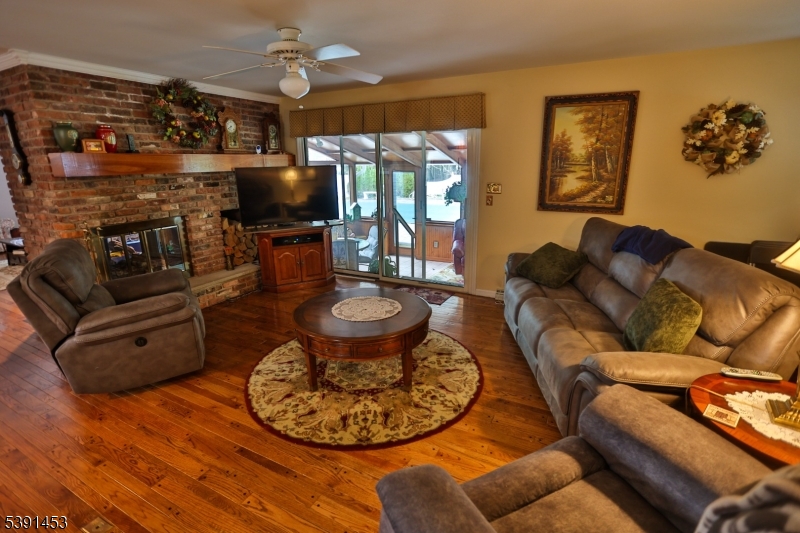47 New Mashipacong Road Montague, NJ 07827 - Photo 15 of 42 a living room with furniture a flat screen tv and floor to ceiling window
