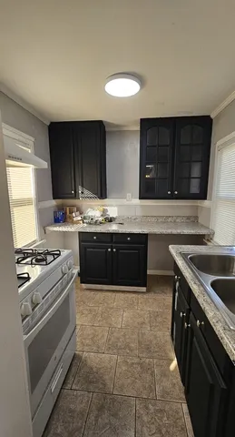 a kitchen with a stove sink and cabinets
