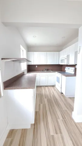 a view of a kitchen with wooden floor