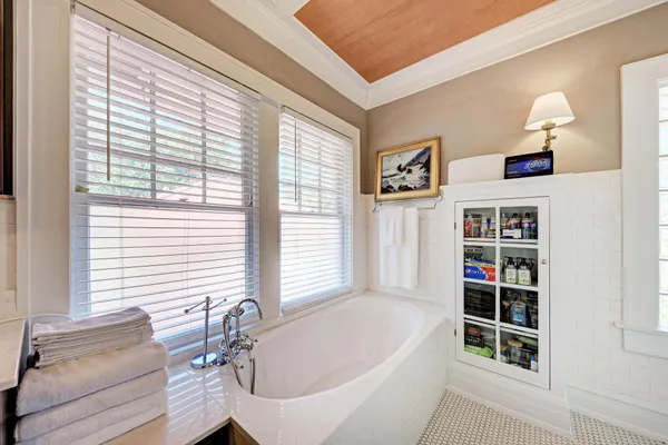 a en suite bathroom with a sink a mirror a window and a shower