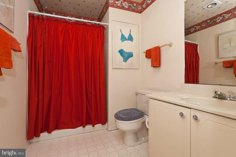 6617 Weymouth Road Baltimore, MD 21212 - Photo 25 of 30 a bathroom with a sink a toilet and shower curtain