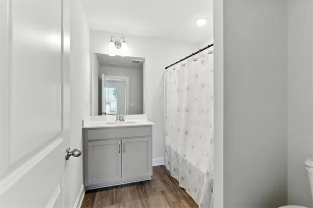 a bathroom with a granite countertop sink a mirror and a shower