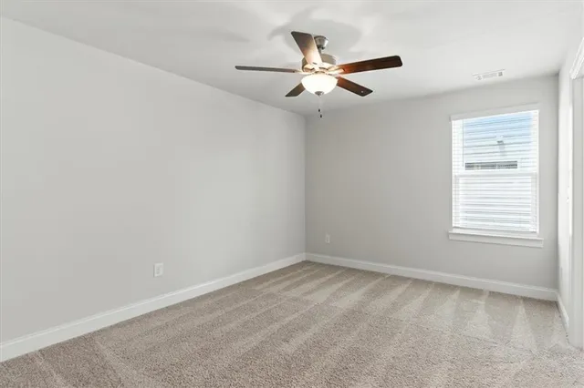 an empty room with a window and a fan