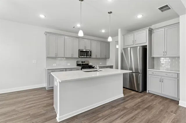 a kitchen with kitchen island white cabinets and stainless steel appliances
