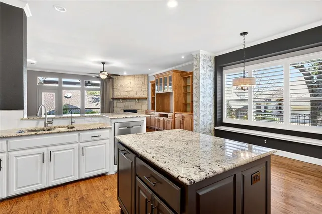 a kitchen with granite countertop sink stove and cabinets