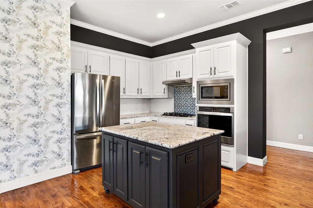 704 Scenic Ranch Circle Fairview, TX 75069 - Photo 15 of 40 a kitchen with stainless steel appliances a refrigerator and a stove top oven