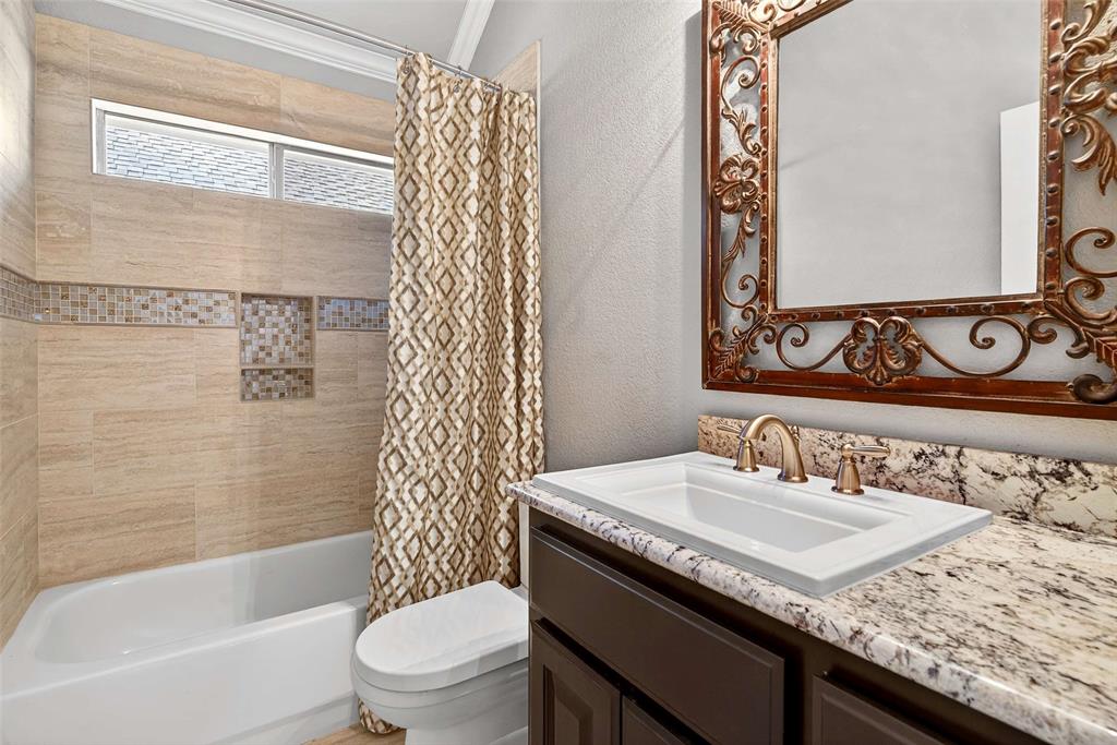 704 Scenic Ranch Circle Fairview, TX 75069 - Photo 22 of 40 a bathroom with a granite countertop sink a toilet and a bathtub