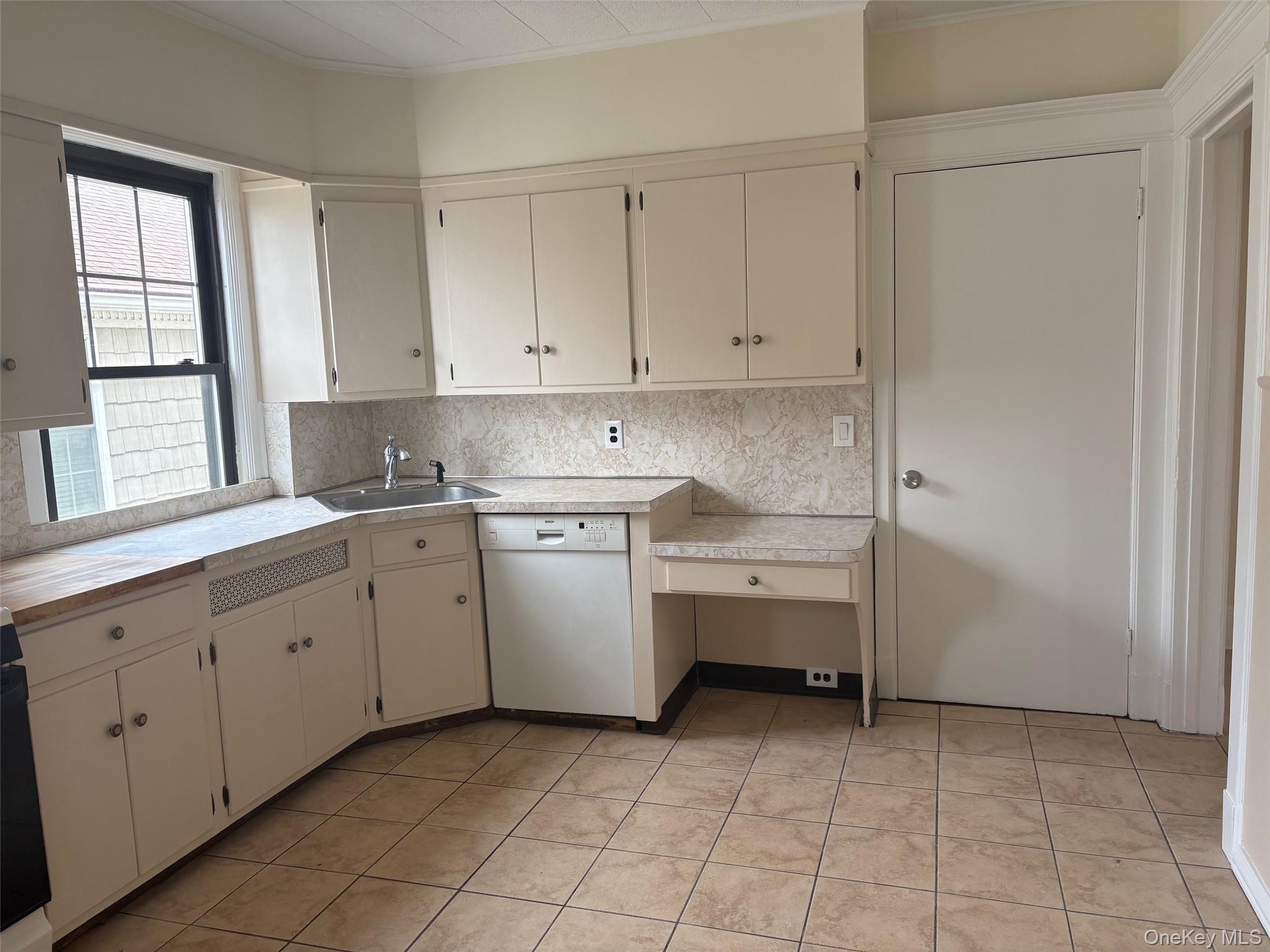 39 Neptune Avenue New Rochelle, NY 10805 - Photo 14 of 28 a kitchen with white cabinets and white appliances