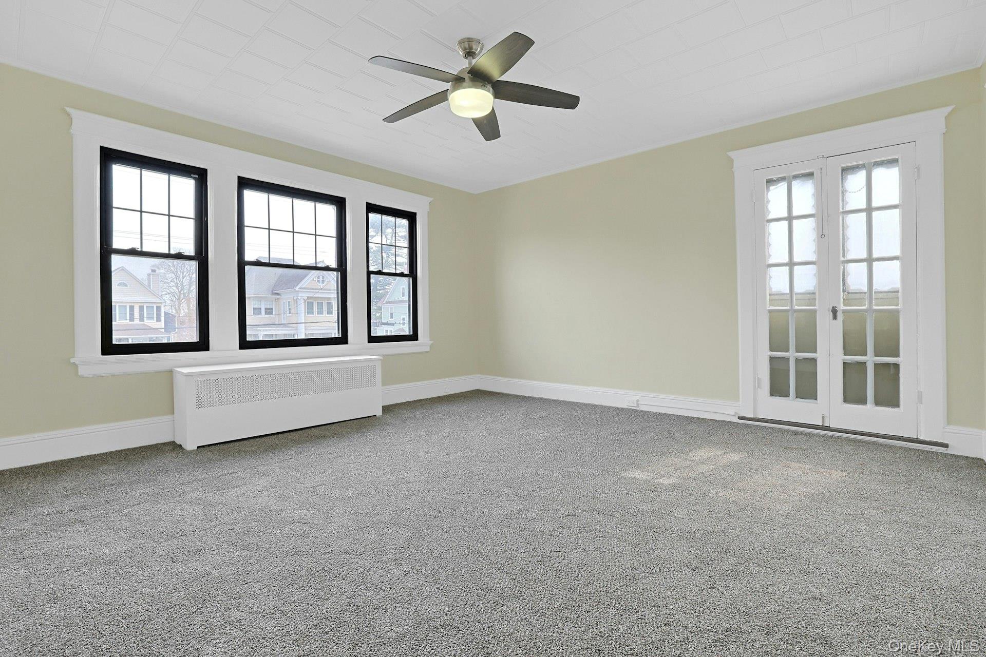 39 Neptune Avenue New Rochelle, NY 10805 - Photo 20 of 28 an empty room with chandelier fan and windows