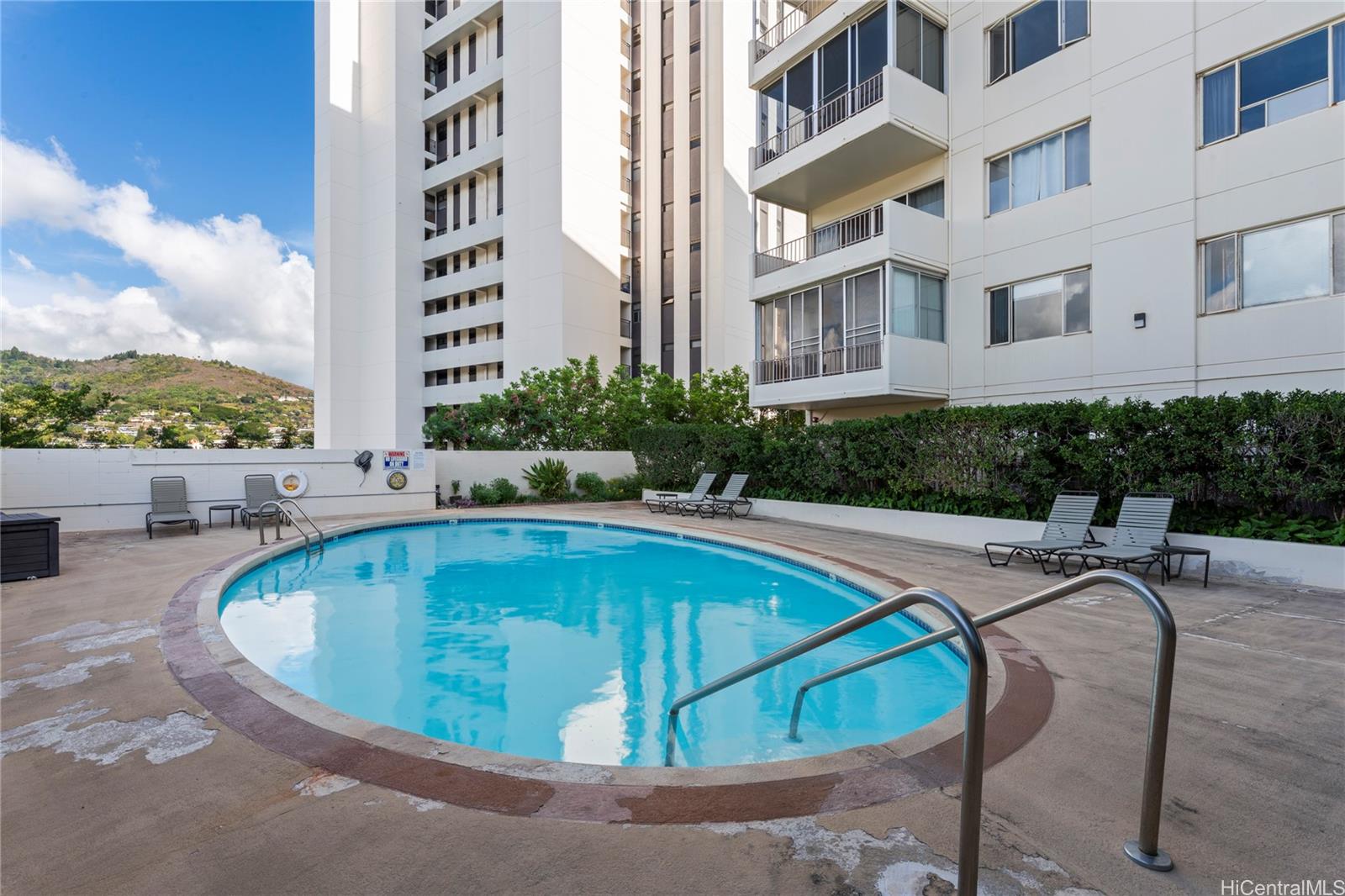 1001 Wilder Avenue, Unit 602 Honolulu, HI 96822 - Photo 18 of 22 a view of swimming pool with outdoor seating and buildings in the background