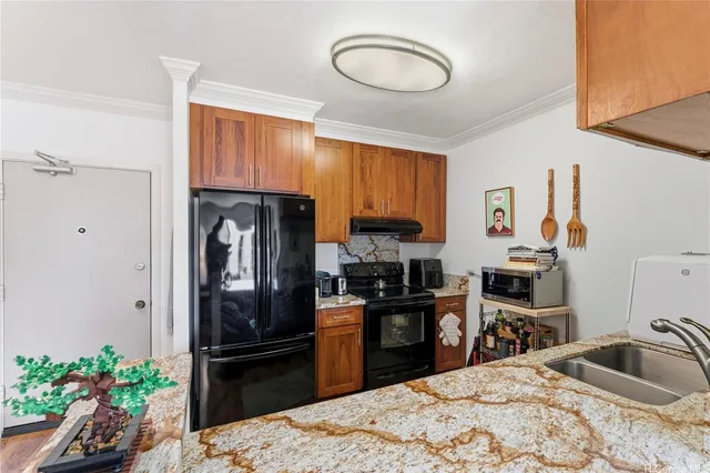 a kitchen with granite countertop a refrigerator stove and sink