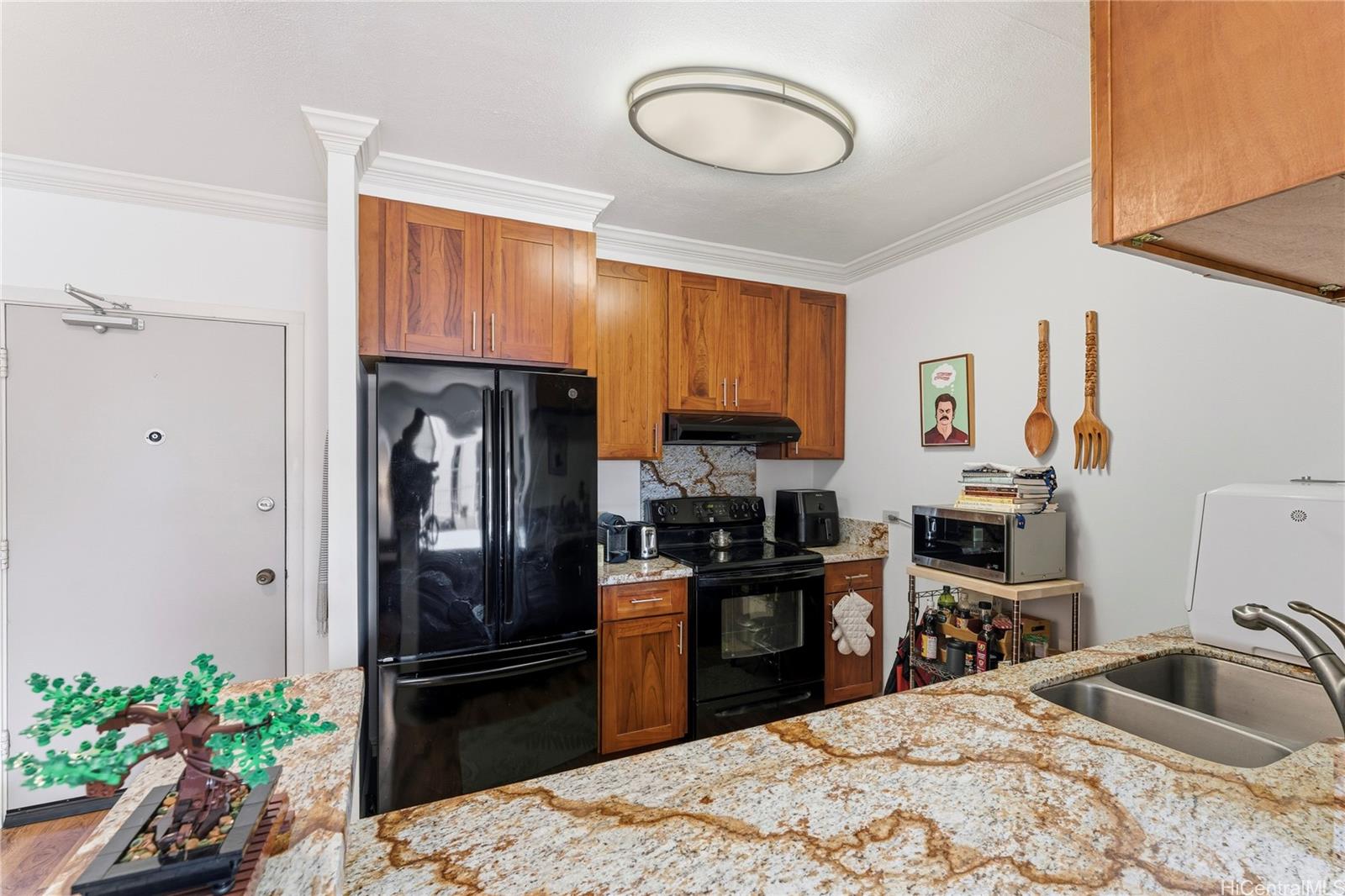 1001 Wilder Avenue, Unit 602 Honolulu, HI 96822 - Photo 7 of 22 a kitchen with granite countertop a refrigerator stove and sink
