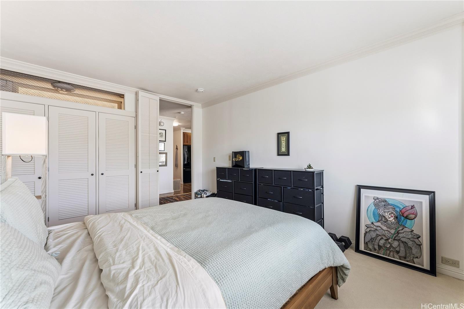 1001 Wilder Avenue, Unit 602 Honolulu, HI 96822 - Photo 10 of 22 a bedroom with a large bed and a chandelier