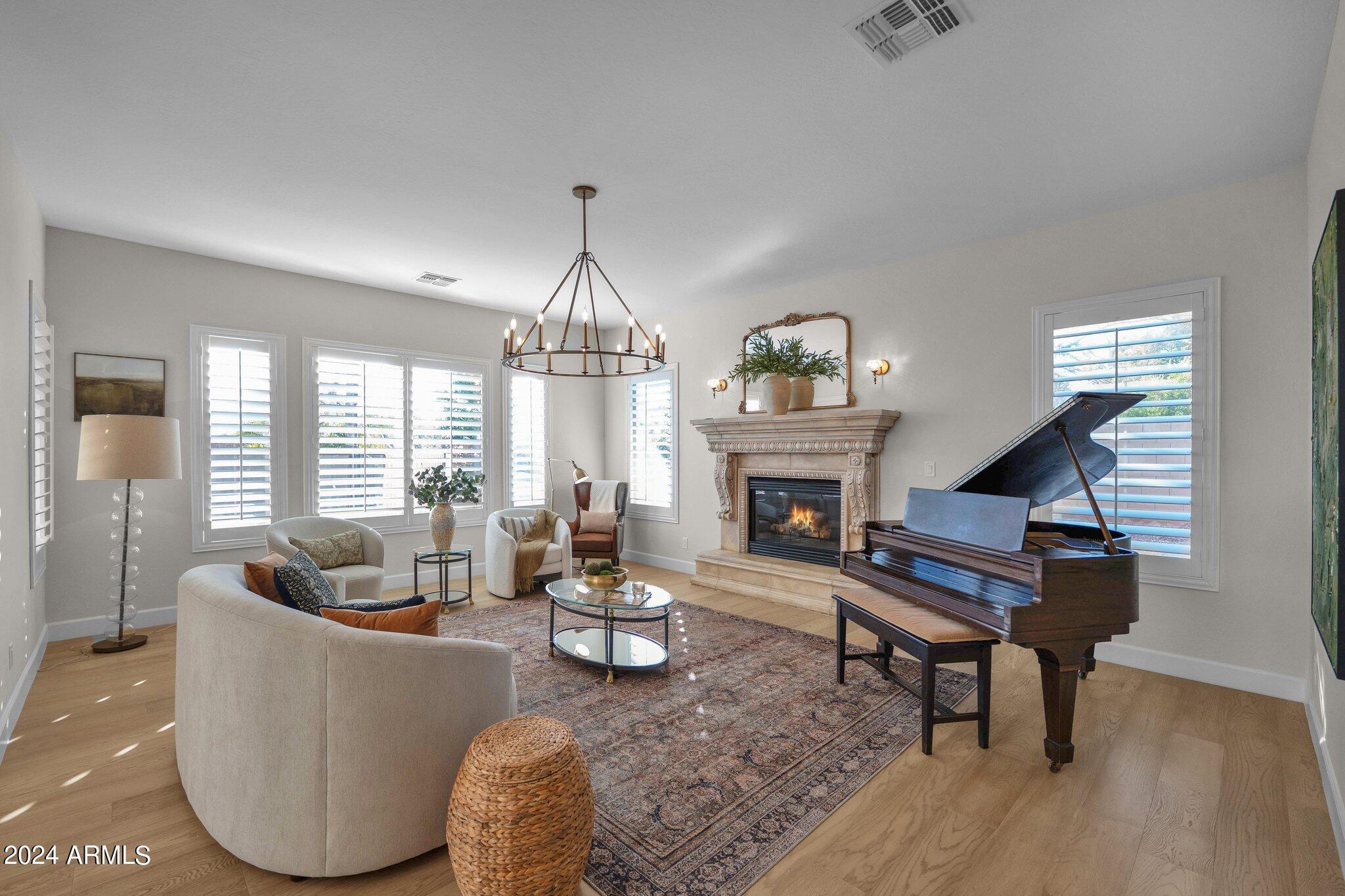 2517 South Constellation Way Gilbert, AZ 85295 - Photo 22 of 105 a living room with furniture a chandelier and a fireplace