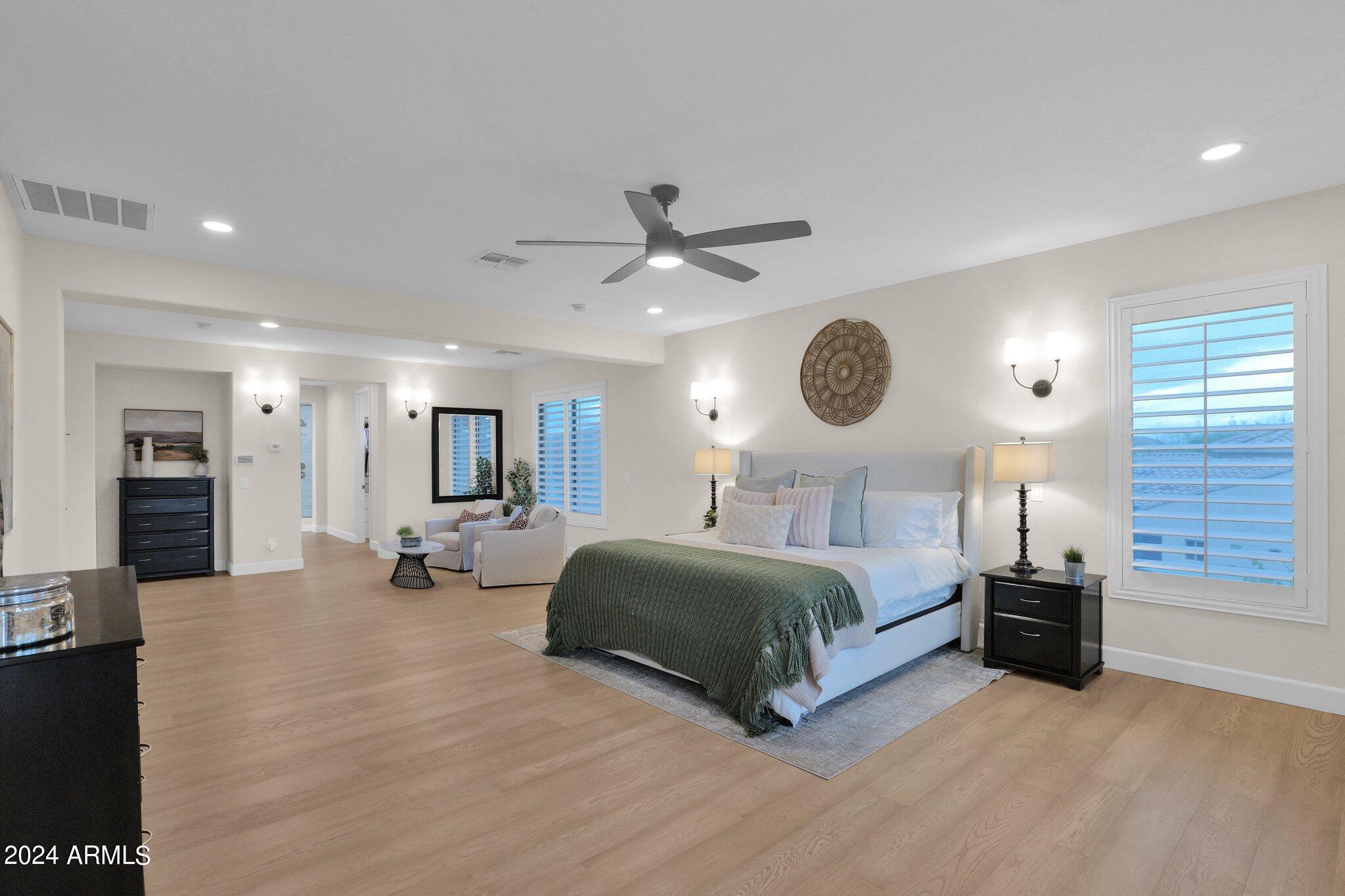 2517 South Constellation Way Gilbert, AZ 85295 - Photo 45 of 105 a spacious bedroom with a bed a chandelier and a television
