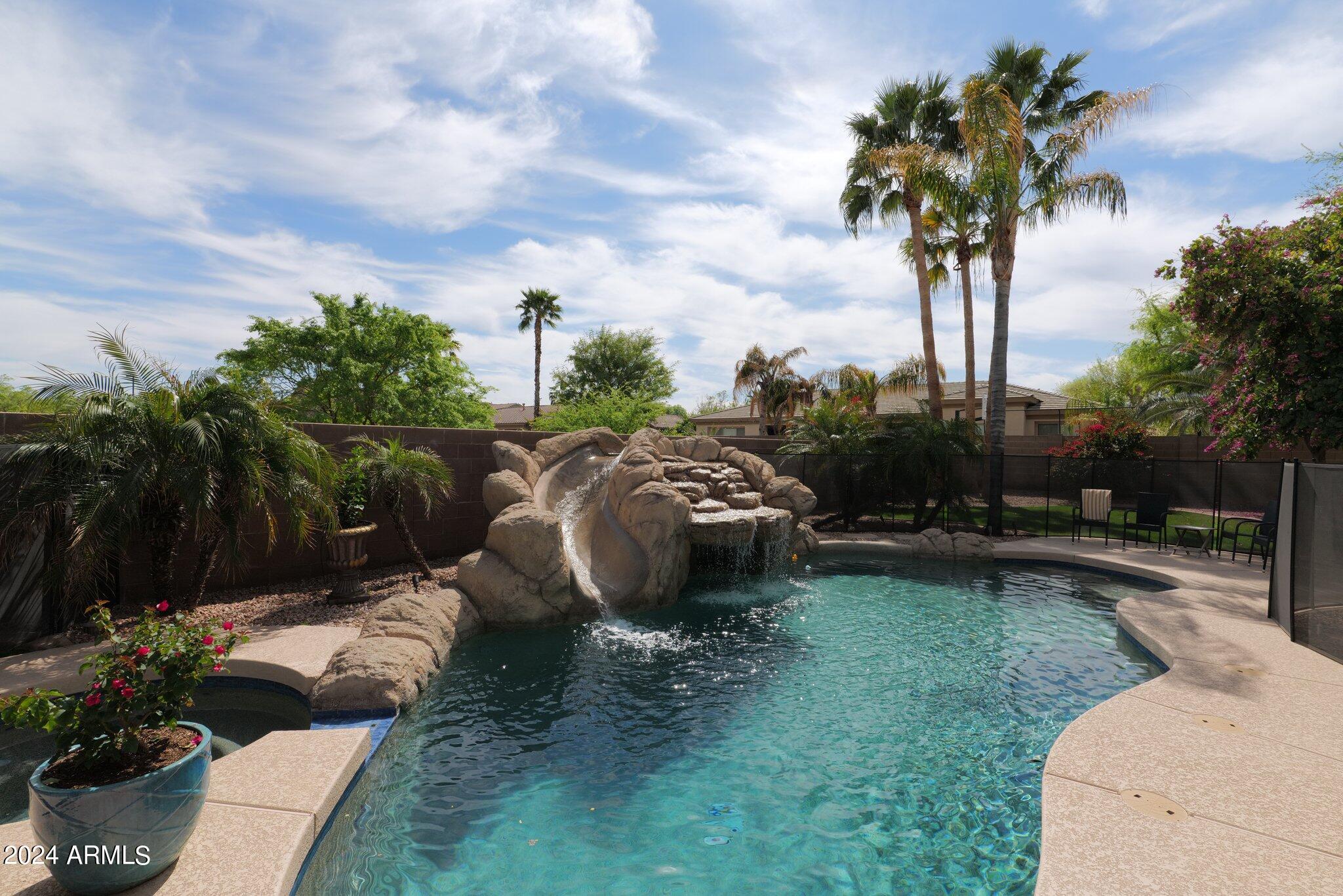 2517 South Constellation Way Gilbert, AZ 85295 - Photo 75 of 105 a view of a backyard with couches plants and palm trees