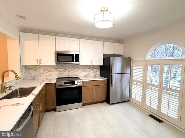 a kitchen with a sink a stove a refrigerator and a window