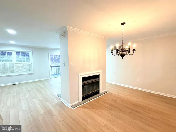 a view of empty room with wooden floor and fireplace