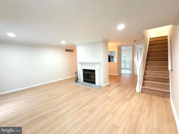 an empty room with wooden floor and fireplace
