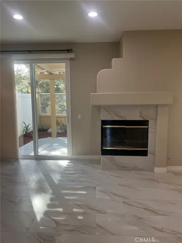 a view of an empty room with glass door and a window
