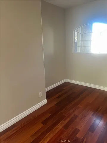 a view of a room with wooden floor and windows
