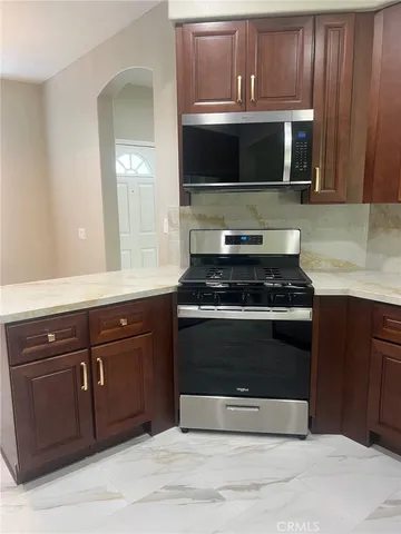 a kitchen with stainless steel appliances wooden cabinets and a stove top oven