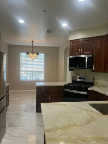 a large kitchen with stainless steel appliances a stove a microwave and a refrigerator