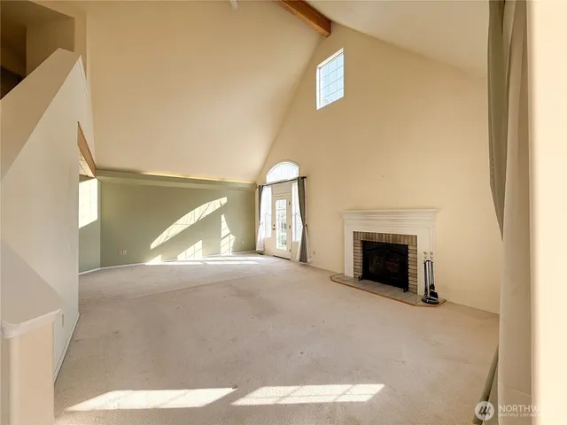 a view of an empty room with a fireplace and a window