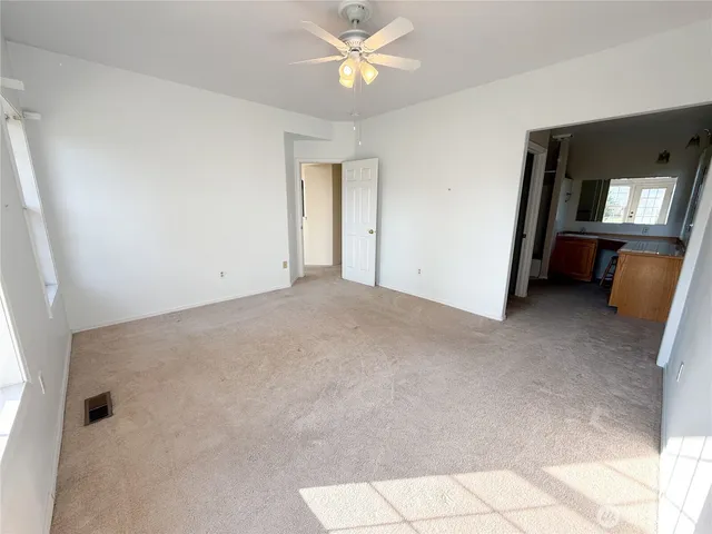 a view of a room with a ceiling fan and window