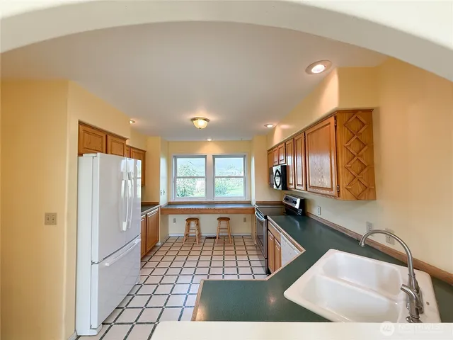 a kitchen with a sink a refrigerator and cabinets